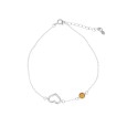 Thin bracelet with honey-colored amber ball and openwork heart in rhodium silver